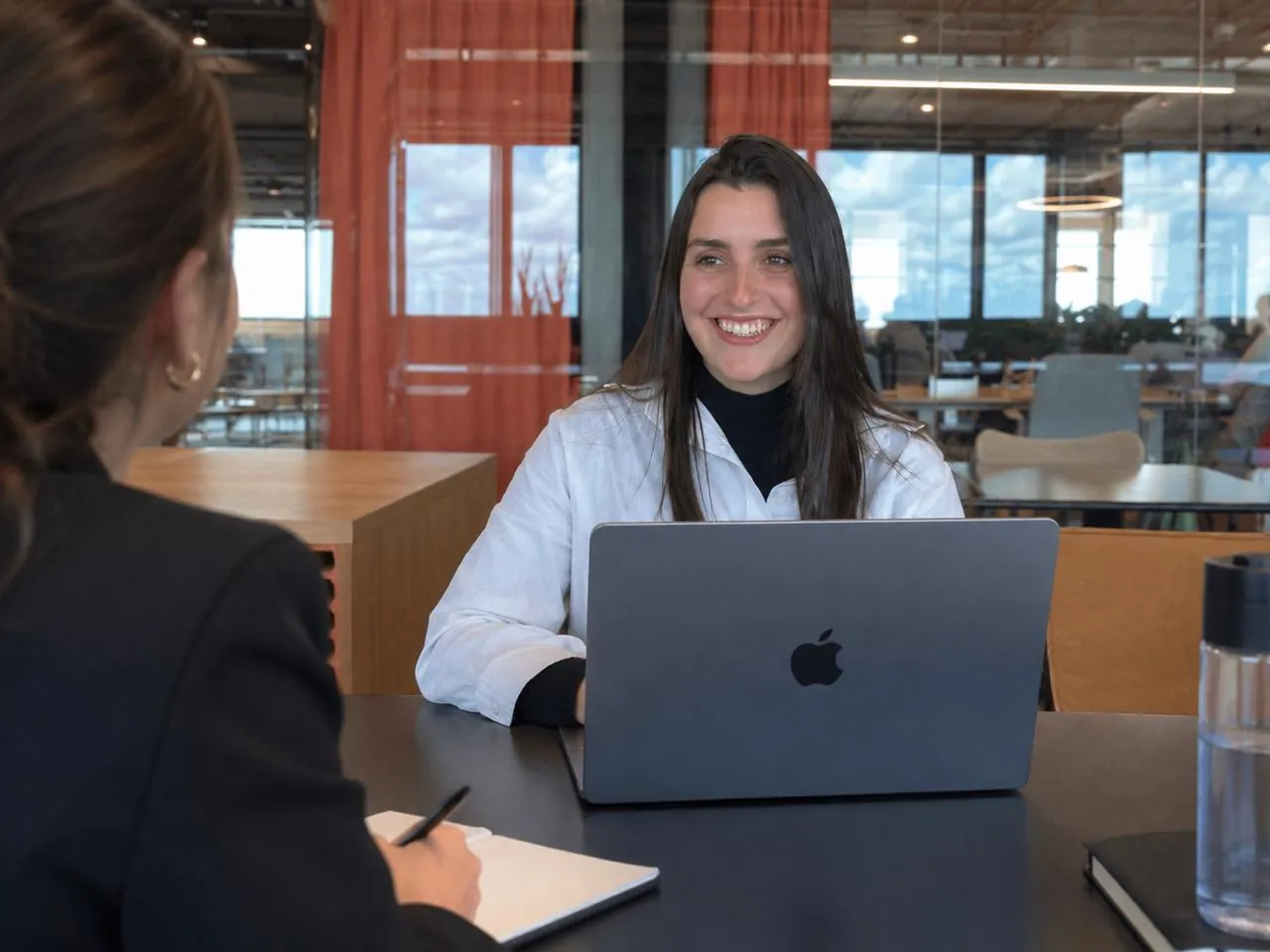 Miri entrevistando a una candidata en una oficina luminosa